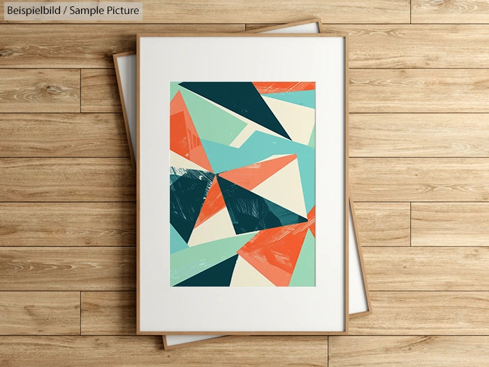 Abstract geometric artwork with teal, peach, and beige shapes in a white frame on a wooden floor.