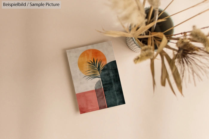 Abstract art print on wall with sun, palm leaves, and geometric shapes in warm tones, near dried flowers in a vase.