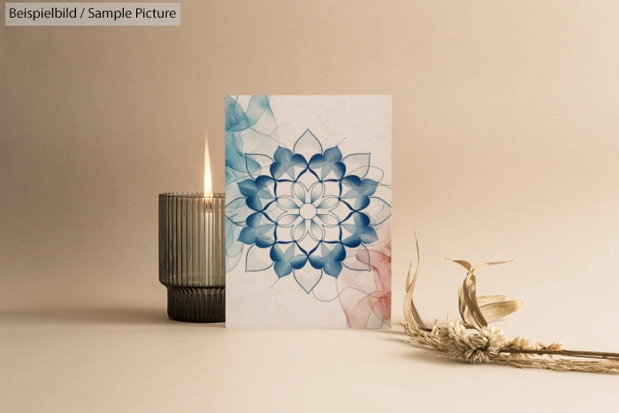 Artistic card with blue mandala design next to a lit candle and dried flowers on a neutral background.