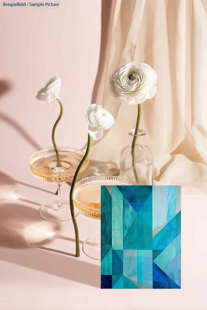 Three white flowers in vases next to champagne glasses, draped fabric background, and abstract blue geometric artwork inset.