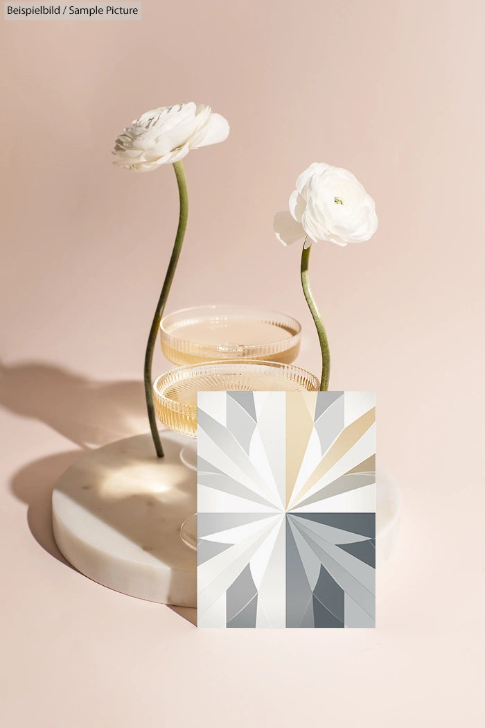 Still life with flowers in glass vases and geometric design print on a marble base.