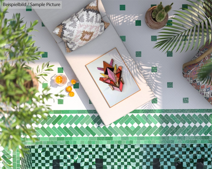 Overhead view of a poolside lounge area with geometric tiles, patterned pillows, and a decorative art piece on a chaise.