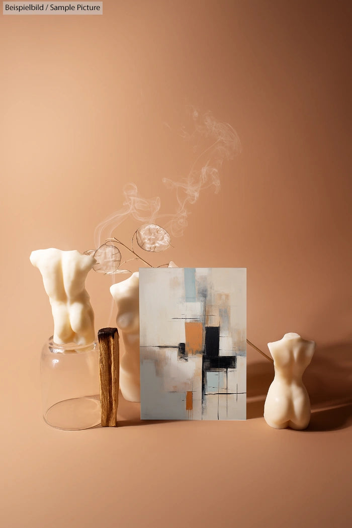 Abstract painting with beige and black squares, displayed with torso-shaped candles and incense sticks on tan background.