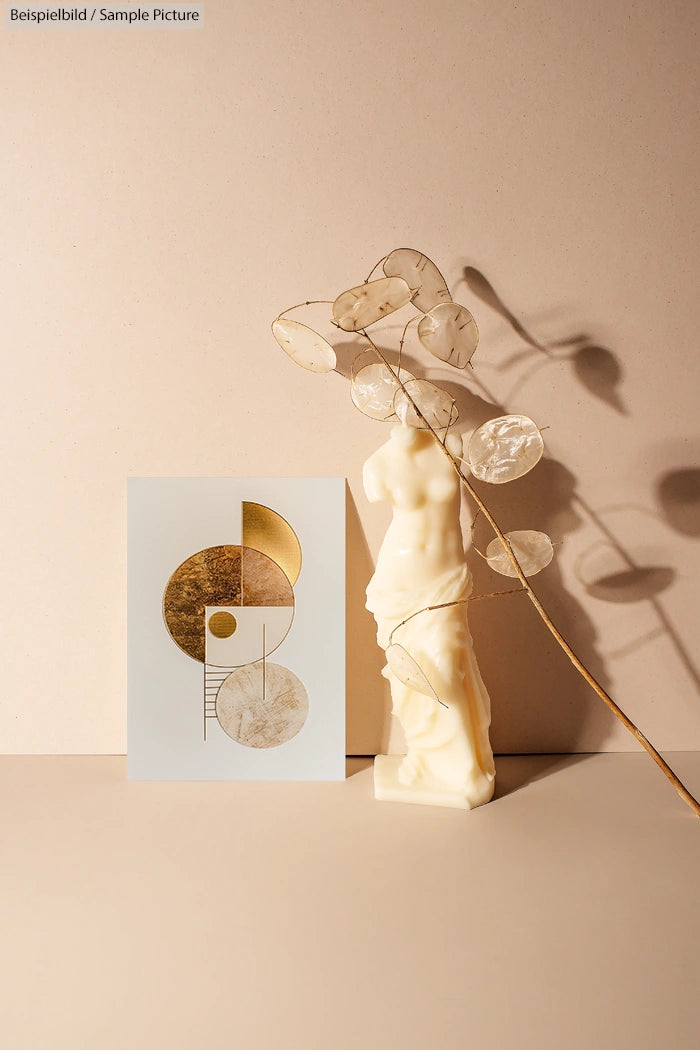 Abstract geometric art with gold circles, next to cream bust sculpture and delicate dried branch on neutral background.