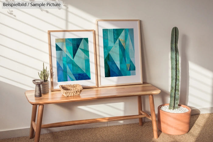 Wooden bench with two framed abstract teal artworks, small plants, and a tall cactus in a minimalistic room.