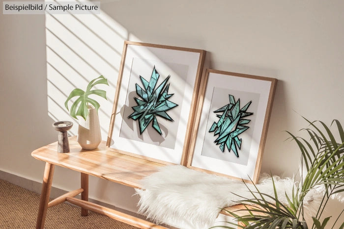 Two framed abstract artworks on wooden bench next to potted plants in sunny room.