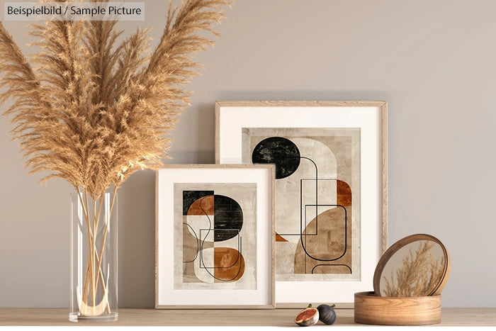 Modern interior with abstract art, dried pampas grass in vase, mirror, and decorative fruit on a wooden surface.