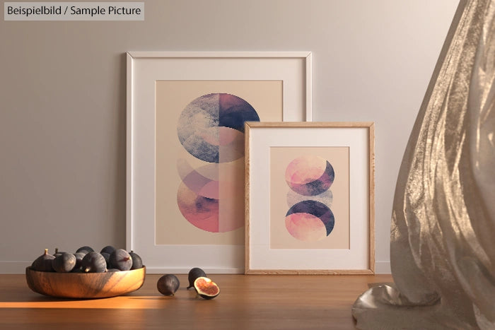 Artistic photo of abstract prints in frames with figs on wooden floor, natural light casting shadows.