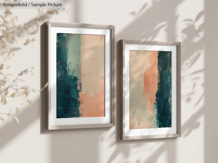 Two framed abstract paintings with teal and peach tones on a wall with shadow patterns.