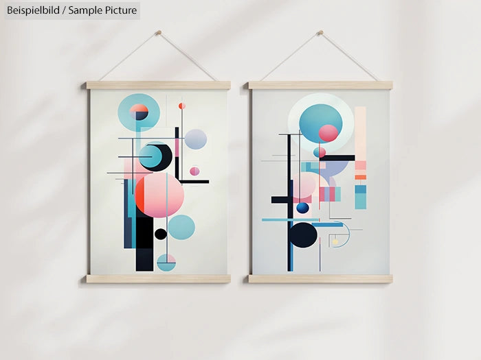 Two abstract geometric art prints with circles and lines, in pastel shades, mounted on a white wall with wooden frames.