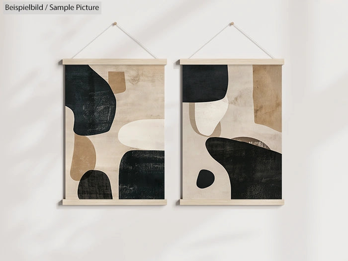 Abstract art prints with organic shapes in black, white, and beige tones, hanging on a light wall.