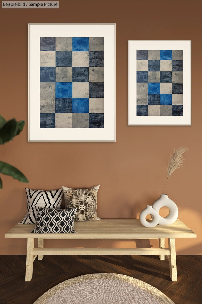 Geometric abstract art with blue and gray squares, displayed on a brown wall above a wooden bench with decorative pillows.