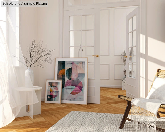 Bright room with abstract art prints, wicker chair, and light-colored decor.