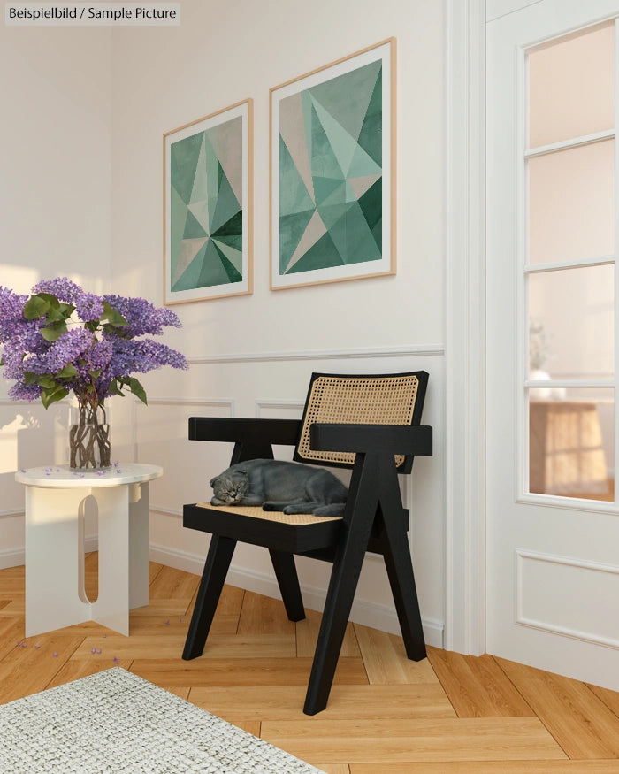 Gray cat sleeping on a black chair beside a table with purple flowers; modern geometric art on the wall.