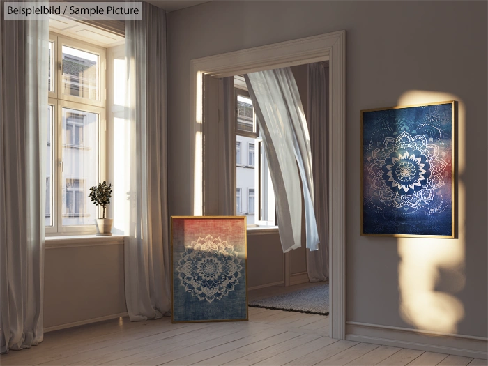 Sunlit room with two mandala paintings, one on the wall and one leaning, near windows and sheer curtains.