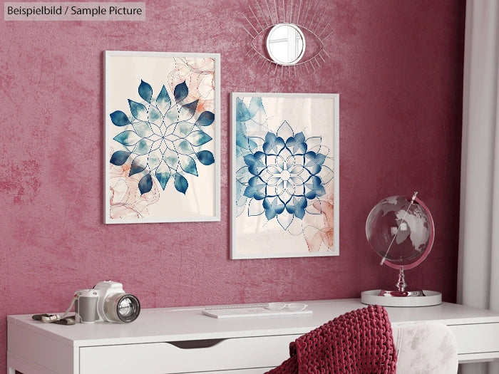 Room with two abstract floral art pieces, white desk, globe, and camera against a maroon textured wall.