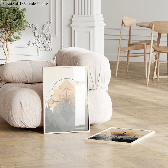 Elegant room with plush beige sofa, two framed abstract artworks on light wood floor, white walls, and modern chairs.