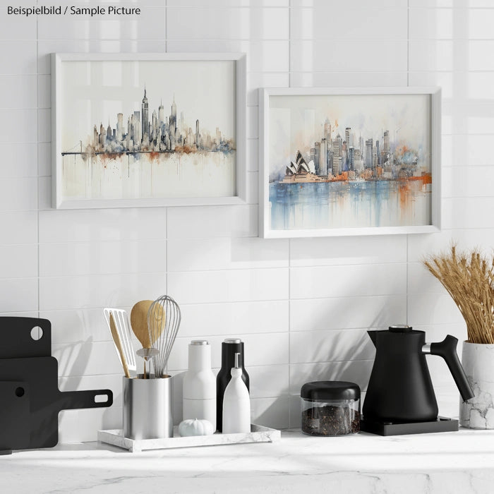 Modern kitchen with white tiled wall, featuring framed cityscape paintings and black kitchen utensils on a counter.