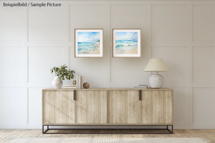 Minimalist living room with wooden sideboard, beach paintings, and modern decor under soft lighting.