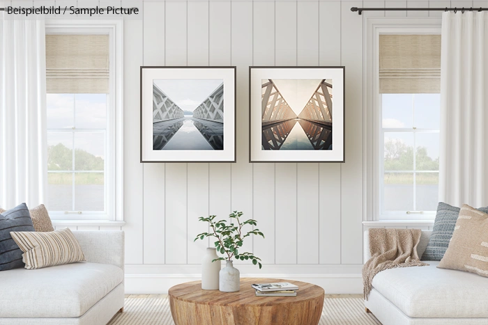 Minimalist living room with two framed geometric bridge photos, white walls, sofa, and wooden coffee table.