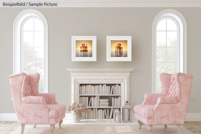 Elegant living room with pink armchairs and framed sunset photos above a bookshelf, flanked by arched windows.