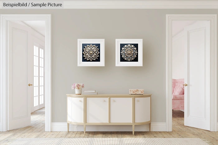 Elegant room with two framed floral art pieces above a beige sideboard, white doors, and soft decor accents.