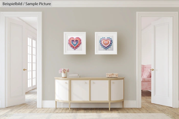 Elegant living room with a sideboard and artworks featuring heart designs on a neutral-colored wall.