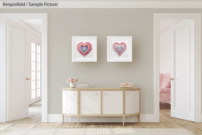 Elegant hallway with art, featuring two heart-shaped mixed media pieces, above a modern console table and soft lighting.