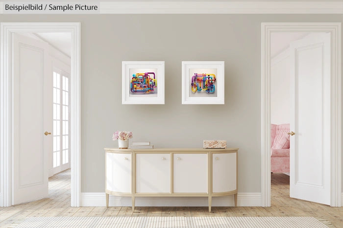 Modern living room with abstract artwork on walls and a white sideboard with decor in between two open doorways.