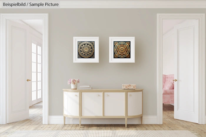 Neutral living room interior with two framed art pieces above a white sideboard, featuring soft lighting and wooden floors.