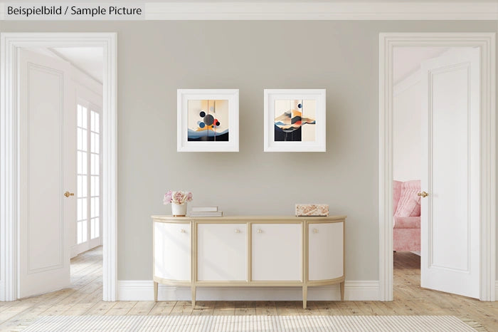 Minimalist hallway with modern art, pale walls, and a white sideboard under two framed abstract prints.