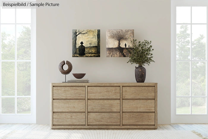 Minimalist living room with wooden dresser, abstract wall art, and large plant in vase.