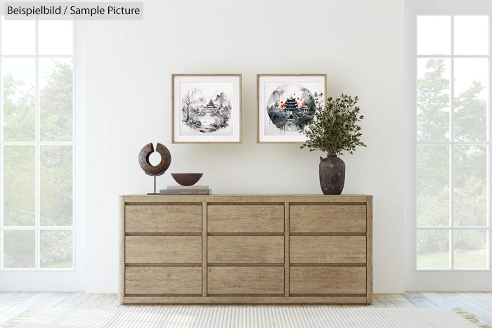 Minimalist room with wooden sideboard, decorative sculpture, vase, and wall art under two large windows.