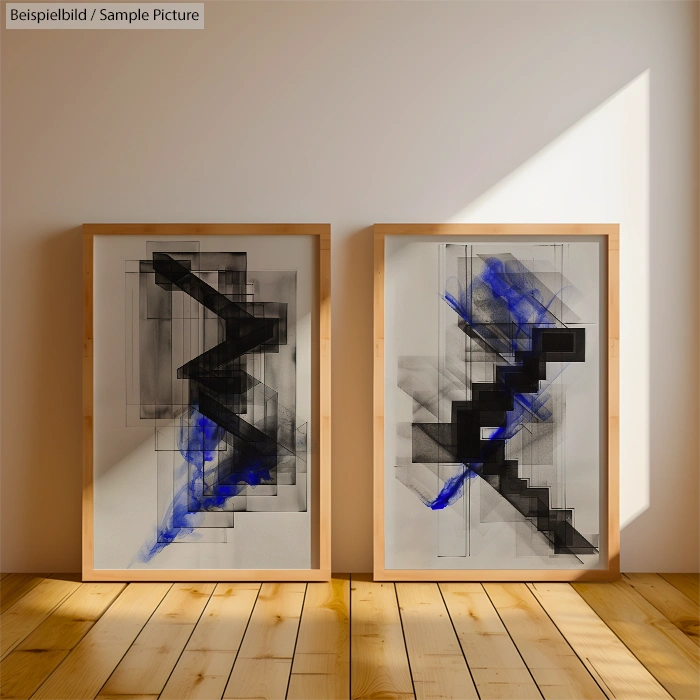 Two abstract paintings with black and blue geometric shapes, framed on a wooden floor, illuminated by sunlight.