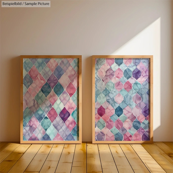 Two abstract paintings with geometric patterns in shades of pink, blue, and purple, framed and displayed on wooden floor.