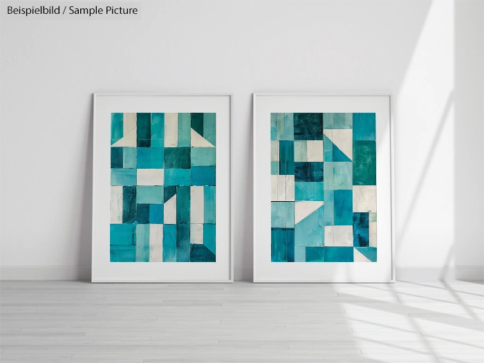 Two framed abstract teal and white geometric paintings on a light-colored floor against a white wall.