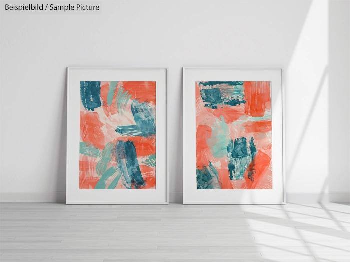 Two framed abstract paintings with bold orange, teal, and pink brushstrokes, mounted on a bright white wall.