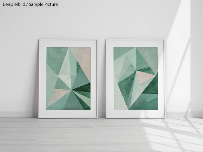 Two framed geometric paintings with shades of green and beige on a white wall in a sunlit room.