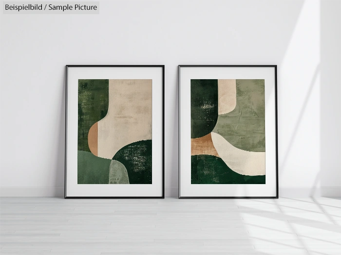 Two framed abstract paintings with green, beige, and brown shapes on a white wall, standing on a light wood floor.