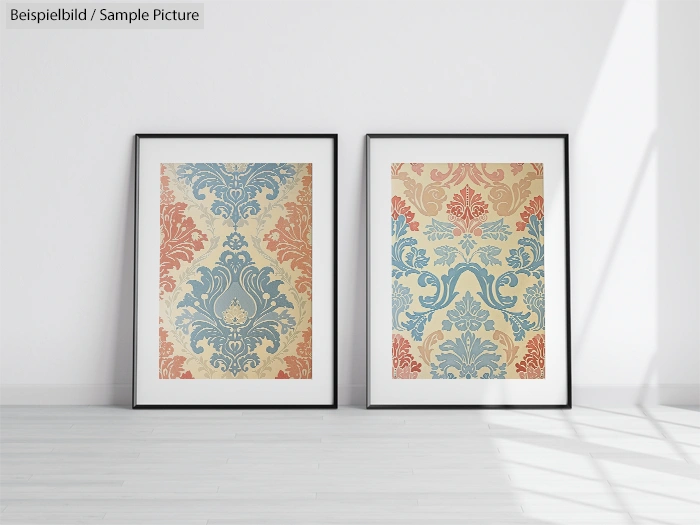 Two framed vintage-style prints with intricate floral patterns in blue and red on a light grey wall.