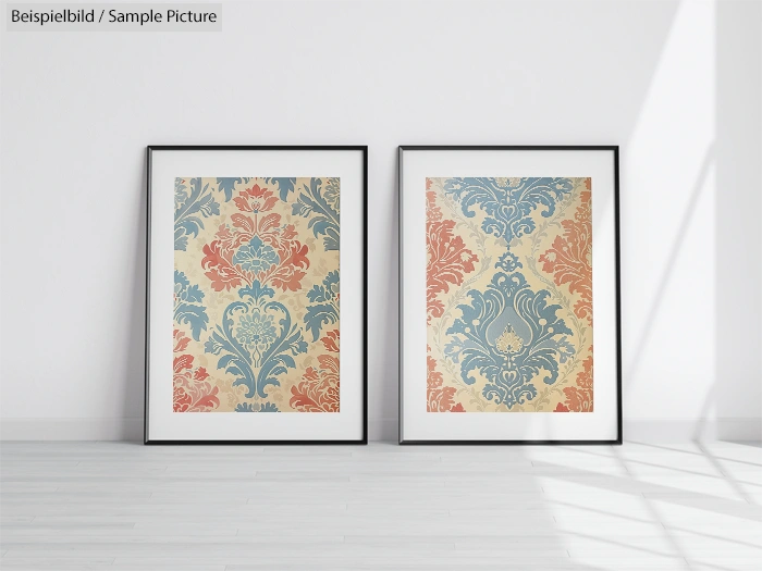 Two framed artworks with intricate blue and orange ornamental patterns on a light wall, casting soft shadows.