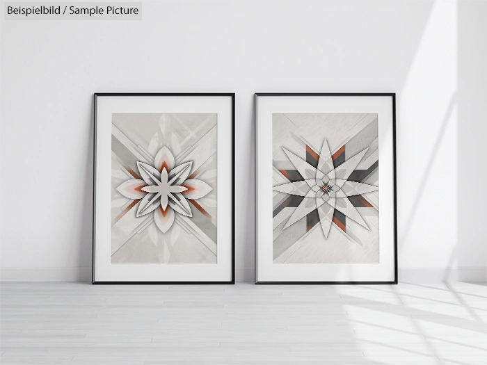 Two geometric art prints in black frames on a minimalist white wall with shadow play.