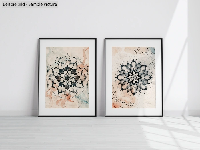 Two framed mandala artworks with floral designs, displayed on a wooden floor against a white wall.