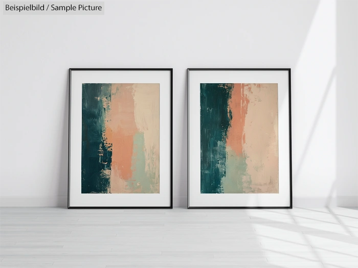 Two framed abstract paintings with blue, peach, and beige textured stripes, leaning against a white wall in bright light.