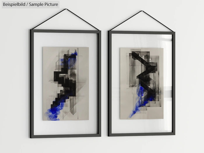 Two framed abstract artworks featuring geometric black and blue shapes on a light background, hanging on a white wall.