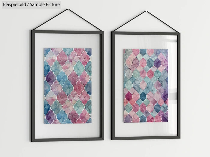 Two watercolor paintings in geometric patterns, framed and hanging on a wall.