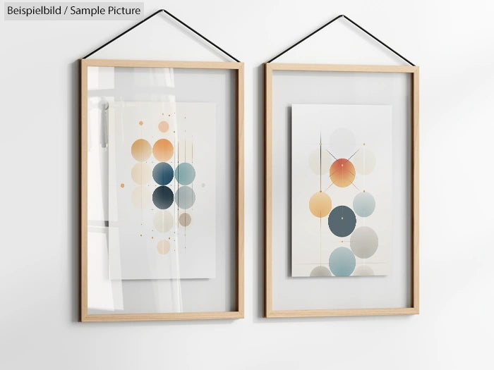 Two framed abstract prints with geometric circles in muted tones, hung on a light-colored wall.