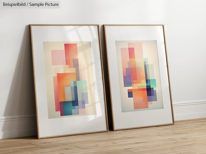 Two modern abstract paintings with colorful geometric patterns in wooden frames, leaning against a white wall on wooden floor.