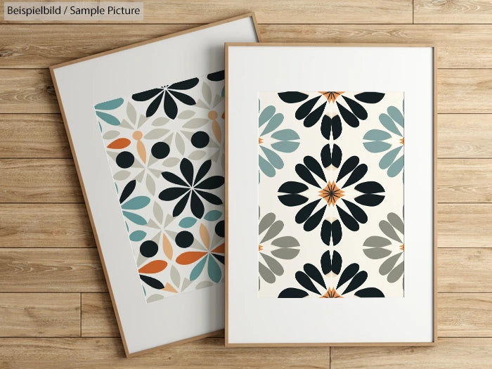 Two framed abstract floral prints with geometric patterns on a wooden floor background.