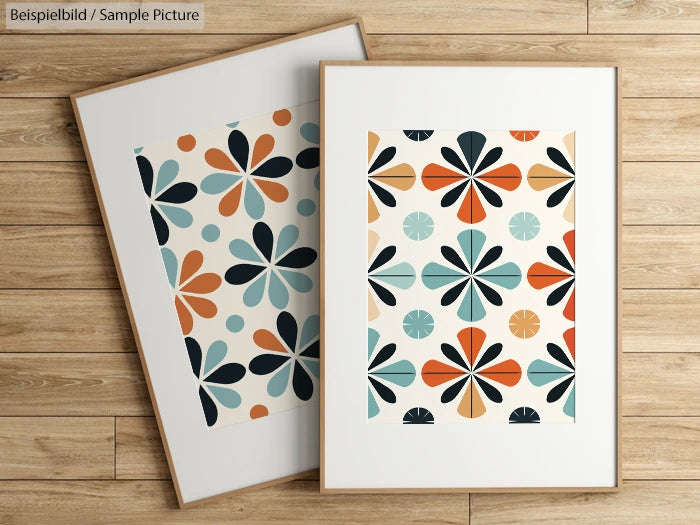 Two framed prints with retro floral patterns in teal, orange, and navy on hardwood floor.